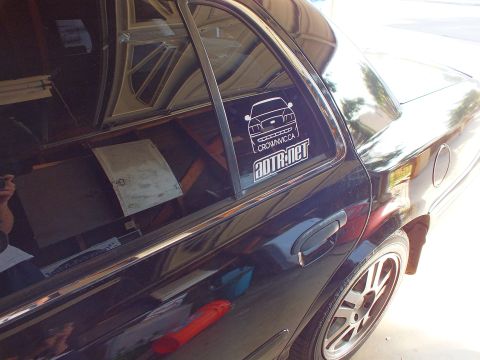 2003 Ford Crown Victoria - Rear quarter of a black sedan with CrownVic.ca and ADTR.net window decals and a polished alloy wheel