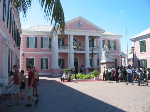 1992 Ford Bronco - A group of people stand in front of a pink colonial building with a statue and a clock tower.