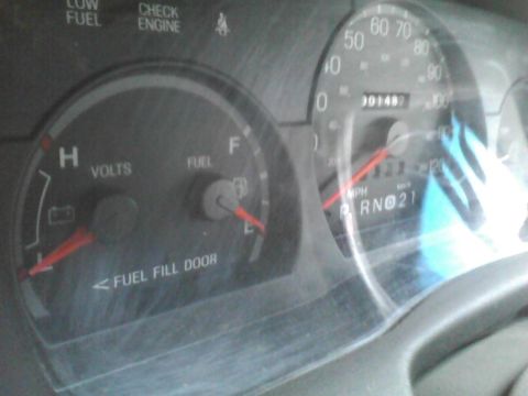 2003 Ford Crown Victoria - The dashboard shows a fuel gauge, voltmeter, and speedometer with an odometer reading of 14,87 miles.