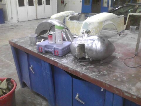 2003 Ford Crown Victoria - Car body parts are laid out on a workbench in a repair shop, ready for work.