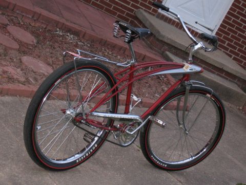 1994 Ford Bronco - A red cruiser bicycle with chrome accents and red-striped Bontrager tires is parked on a concrete path.