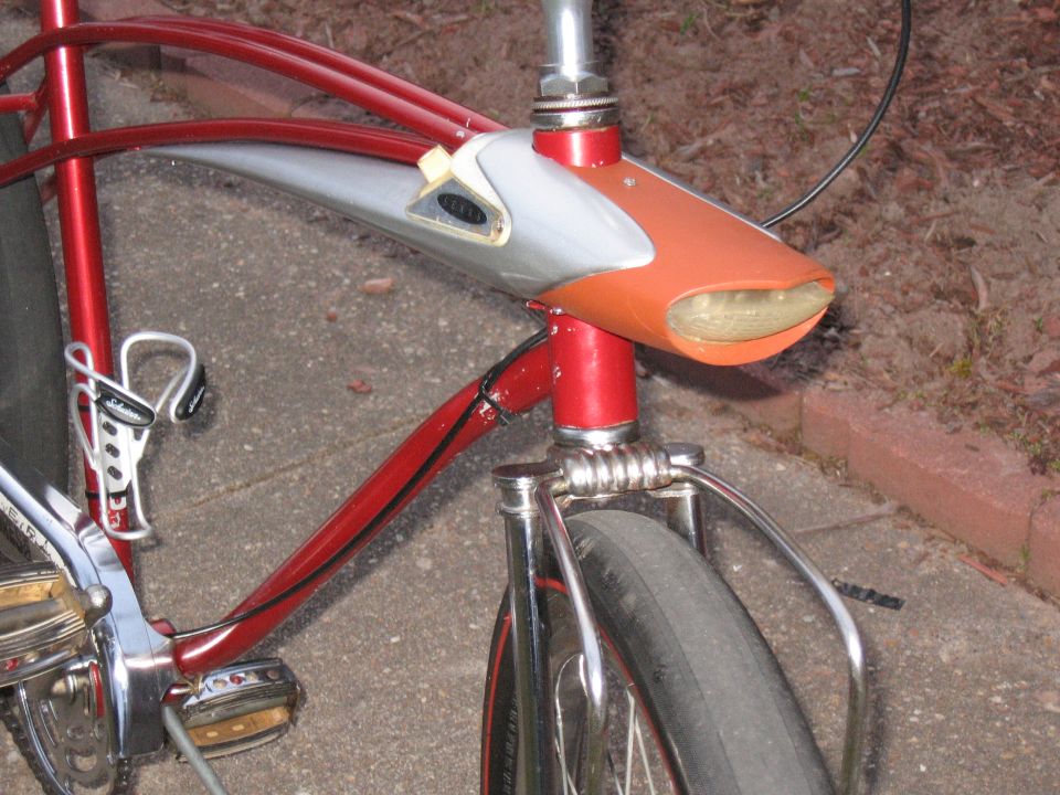 red bicycle frame with silver and orange headlight assembly