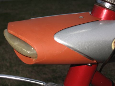 1994 Ford Bronco - This is a close-up view of a bicycle's headlight housing, which is painted orange and silver.