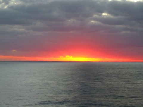 1992 Ford Bronco - Sunset over the ocean with clouds and a faint horizon line.