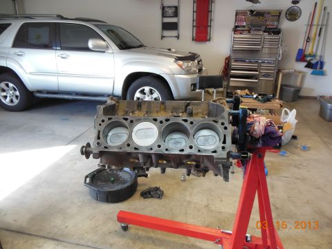 1979 Ford F-150 - Engine block on a stand in a garage with a silver SUV parked behind it.