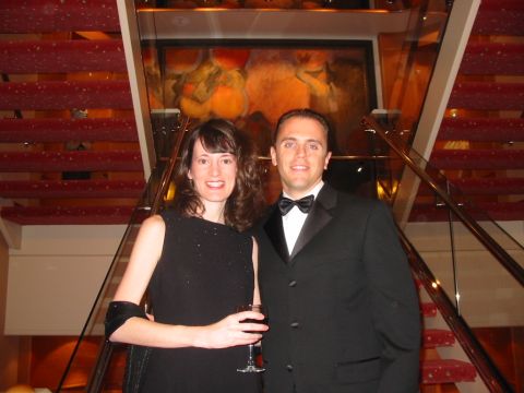 1992 Ford Bronco - A couple dressed in formal attire poses for a photo on a red carpeted staircase with a decorative mural in the background.