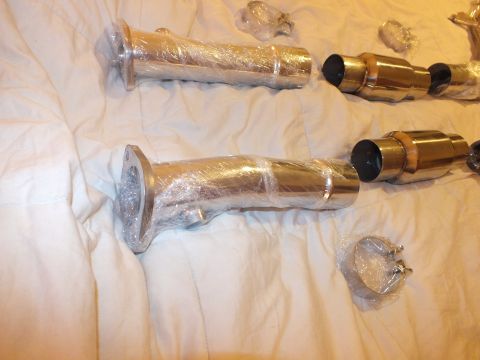 2003 Ford Crown Victoria - Two polished stainless exhaust mid-pipes with brass-colored ball flanges, wrapped, laid on a bed