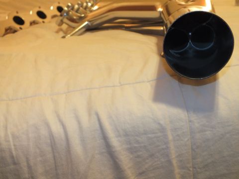 2003 Ford Crown Victoria - Polished exhaust collector end revealing two merged pipe outlets, on white bedding