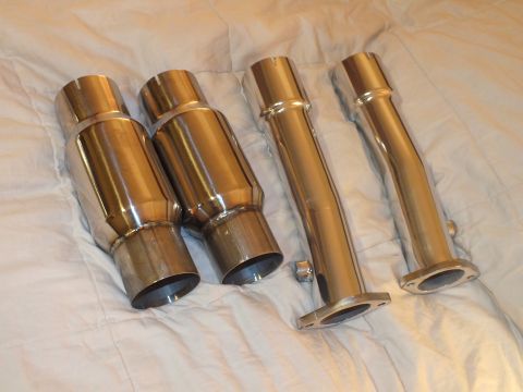 2003 Ford Crown Victoria - Stacked dual-wall exhaust tips beside two flanged connector pipes and a hardware nut