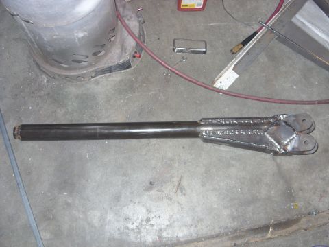 1967 Ford F-250 - A fabricated metal suspension component rests on a workshop floor, showing visible welds and mounting points.