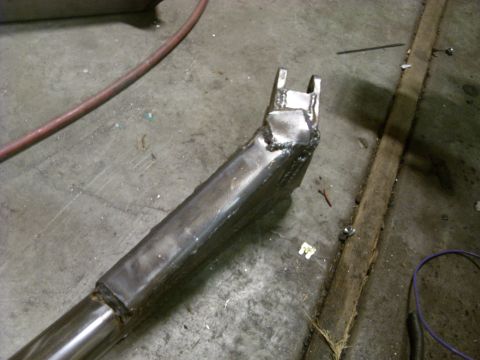 1967 Ford F-250 - A fabricated metal component with rough welds is shown on a workshop floor.