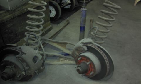 1967 Ford F-100 - Vehicle suspension components, including coil springs and disc brakes, are laid out on a garage floor.