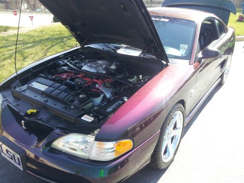 1965 Ford Mustang - A purple 1994 Ford Mustang coupe is shown with its hood open, revealing the engine and custom wheels.