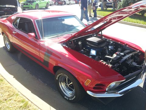 1965 Ford Mustang - Red 1970 Ford Mustang Boss 302 displayed with its hood open at a car show.