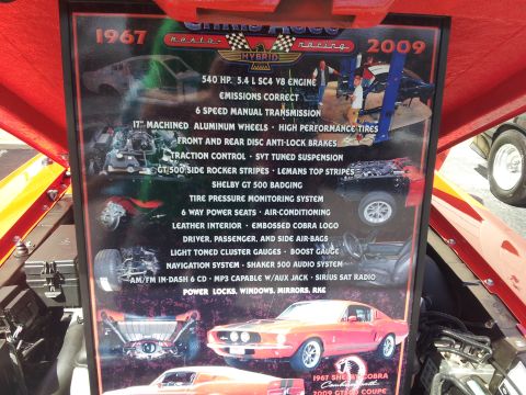 1965 Ford Mustang - A display board lists specifications for a hybrid car, referencing 1967 and 2009 models.