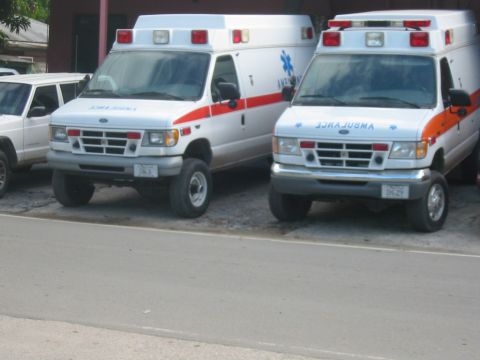 1992 Ford Bronco - Two Ford ambulances are parked on a street, with a white SUV visible to the left.