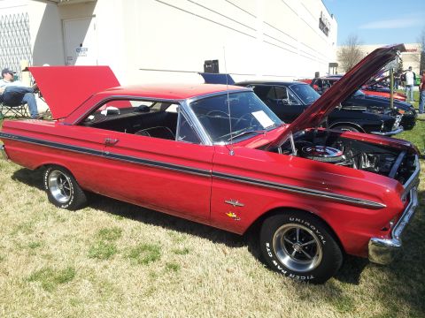 1965 Ford Mustang - A red 1964 Ford Falcon coupe is displayed with its hood and trunk open at an outdoor event.