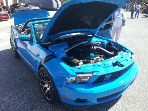 1965 Ford Mustang - This blue Ford Mustang convertible has its hood open, revealing the engine bay.