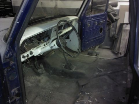 1967 Ford F-100 - The interior of a blue 1967 Ford F-100 truck is visible, with the dashboard and steering wheel in view.