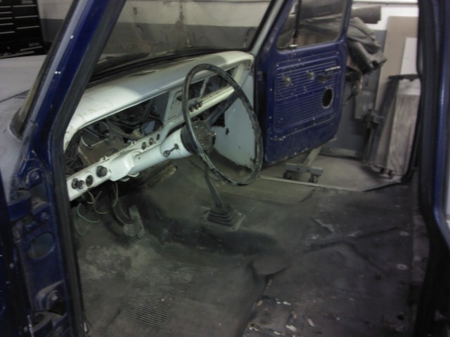 Blue 1967 Ford F-100 interior, showing dashboard, steering wheel, and door panel