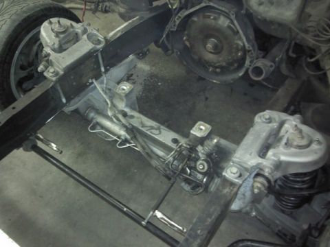 1967 Ford F-100 - The underside of a vehicle is shown, focusing on the chassis, suspension, and transmission assembly.