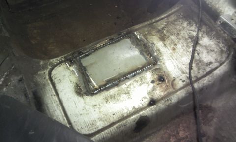 1967 Ford F-100 - Floor pan repair with a welded patch, showing signs of wear and tear.