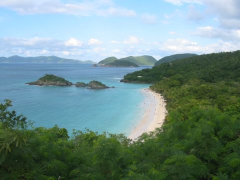 1992 Ford Bronco - A scenic view of a tropical bay with a white sand beach dotted with people.
