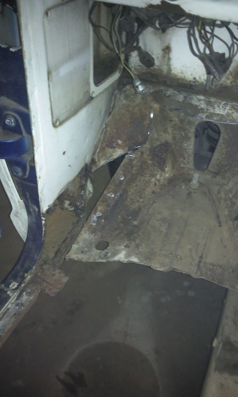 1967 Ford F-100 - The interior floor pan of a 1967 Ford F-100 shows significant rust and exposed wiring.
