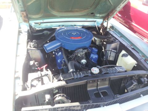 1965 Ford Mustang - The engine bay of a classic car, a blue air cleaner and blue painted valve covers.