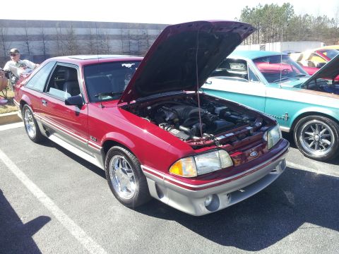 1965 Ford Mustang - A red 1993 Ford Mustang GT is displayed with its hood open, revealing the engine bay.