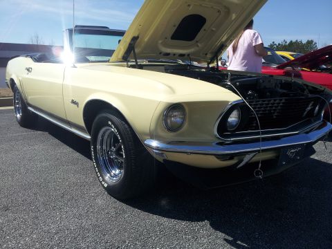 1965 Ford Mustang - This yellow 1969 Ford Mustang convertible is displayed with its hood open, revealing the engine bay.