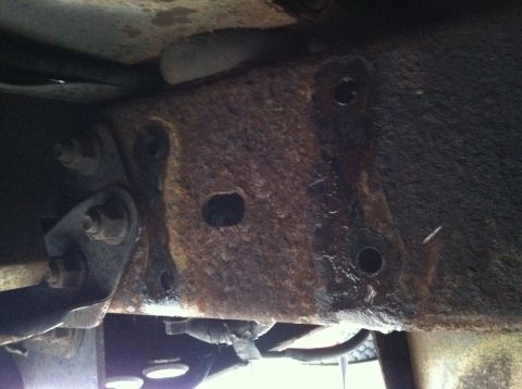 1996 Ford Bronco - Rusted frame section showing mounting points and bolts, likely from a vehicle's undercarriage.