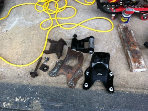 1996 Ford Bronco - Various vehicle suspension components, including old and new parts, are arranged on a concrete surface alongside tools and tools.