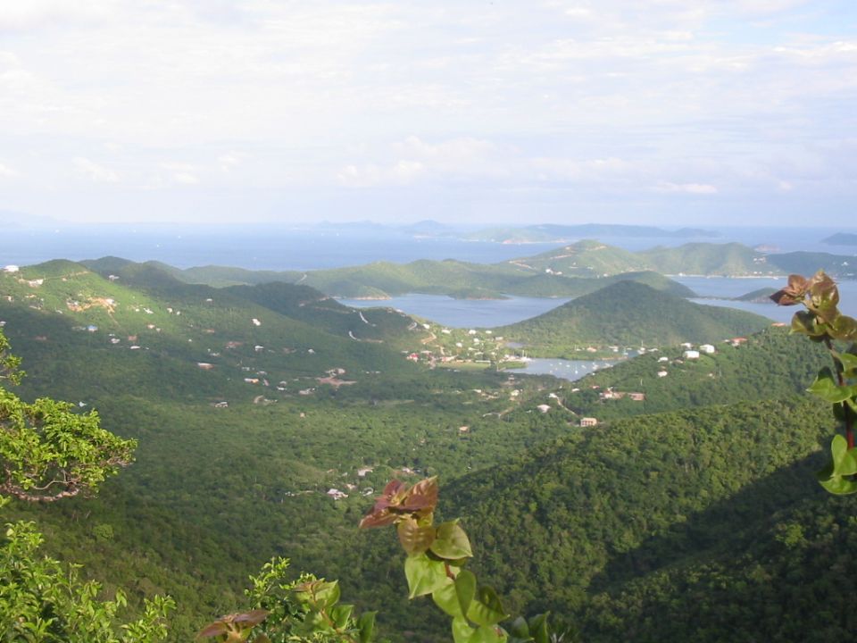Hilltop view of a tropical bay with sailboats and green islands