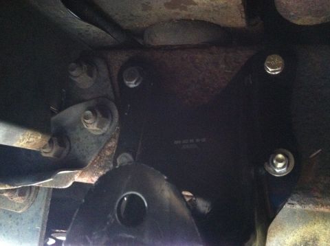 1996 Ford Bronco - A close-up view of a vehicle's undercarriage, focusing on a newly installed bracket and suspension components.