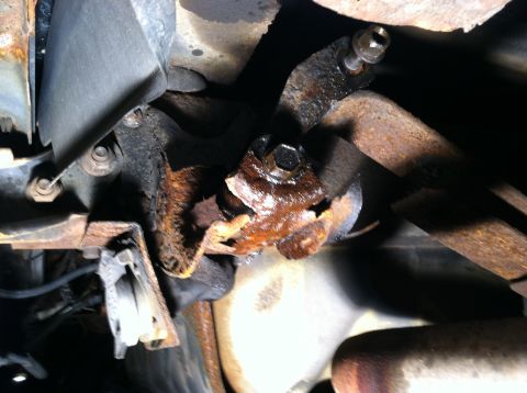 1996 Ford Bronco - Close-up of a corroded metal bracket and bolt, likely part of a vehicle's suspension or frame.