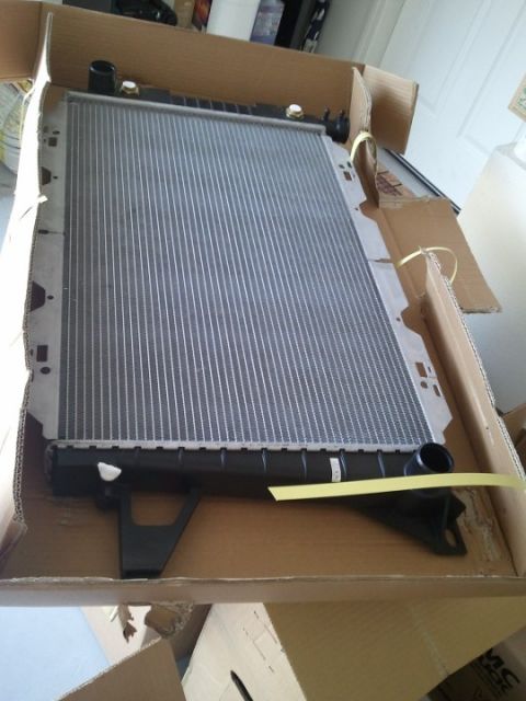 1994 Ford Bronco - New radiator packaged in a cardboard box, ready for installation.