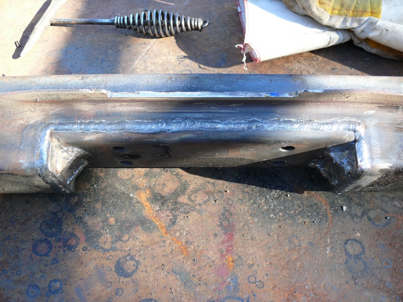 Welded metal frame section with a tool and glove nearby