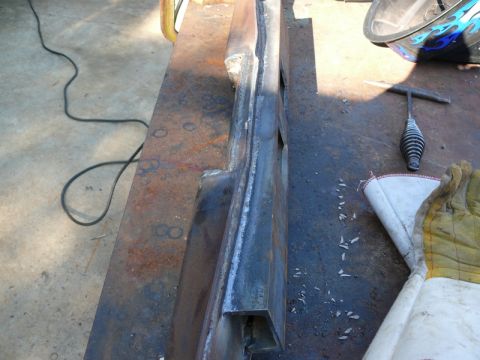 1976 Chevrolet Corvette - A metal component is being worked on, with welding equipment and protective gear present.