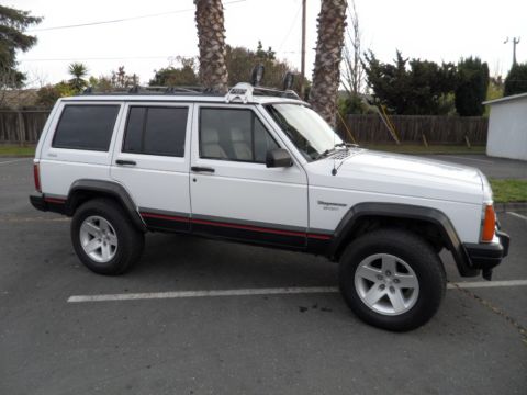 1994 Jeep Cherokee - This white 1994 Jeep Cherokee is seen from a three-quarter front angle in a parking lot.