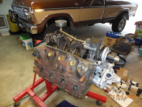 1979 Ford F-150 - Engine on stand in front of a 1979 Ford F-150 pickup truck.