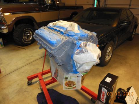 1979 Ford F-150 - Engine assembly on a stand with a truck in the background.