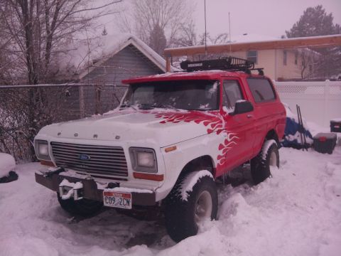 1979 Ford Bronco - A two-tone SUV sits in a snowy landscape, possibly during winter.