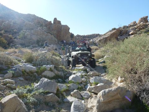 1997 Ford Ranger - A wide shot of a rocky desert canyon with scrub brush and a dry streambed.