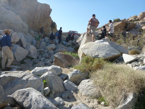 1997 Ford Ranger - A person stands atop rocky terrain under a clear blue sky, surveying the arid landscape.