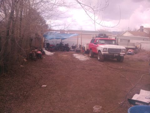 1979 Ford Bronco - Outdoor scene with multiple vehicles obscured by mud and poor lighting conditions.