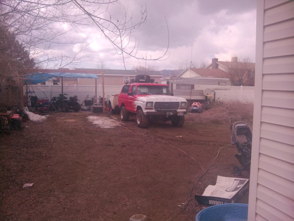 Red and white 1979 Ford Bronco with roof rack and trailer