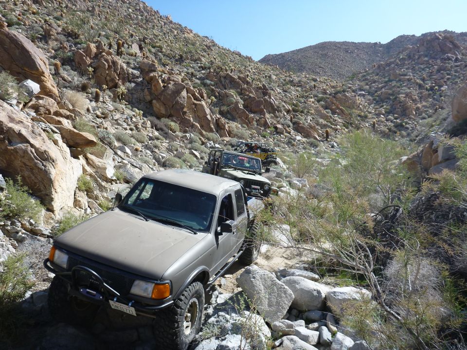1997 Ford Ranger and two Jeeps navigating a rocky desert canyon trail