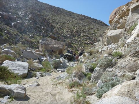 1997 Ford Ranger - Off-road vehicles traverse a challenging rocky terrain in a desert canyon under a clear blue sky.
