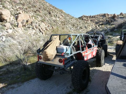 1997 Ford Ranger - Two off-road buggies are parked on a dirt path in a rocky, arid landscape.